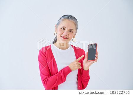 Senior woman pointing at smartphone Senior woman pointing at smartphone 108522795
