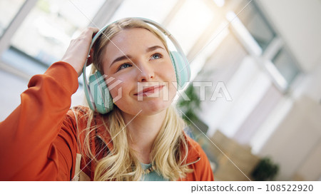 Music, relax and streaming with woman on sofa for podcast, happy and energy. Freedom, media and online radio with person listening to headphones in living room at home for technology, sound and audio 108522920