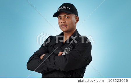 Security guard, portrait and man in studio with arms crossed, walkie talkie and surveillance of law enforcement or on blue background. Serious bodyguard with safety radio for crime, patrol and danger 108523056
