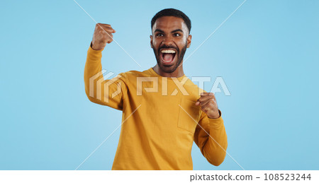 Wow, news and happy man in studio with winner, fist or celebration, dance or victory on blue background. Surprise, success or portrait of guy winner with energetic reaction to prize, giveaway or deal Wow, news and happy man in studio with winner, fist or celebration, dance or victory on blue background. Surprise, success or portrait of guy winner with energetic reaction to prize, giveaway or deal 108523244