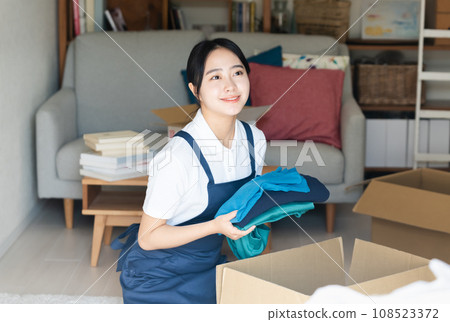 一個年輕的女人搬到工作 108523372