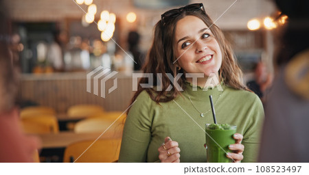 Girl friends, talk and smoothie in cafe, green drink and happy for health, nutrition and juice with smile. Gen z woman, milkshake or diet with group, students and chat in restaurant, diner and cafe Girl friends, talk and smoothie in cafe, green drink and happy for health, nutrition and juice with smile. Gen z woman, milkshake or diet with group, students and chat in restaurant, diner and cafe 108523497