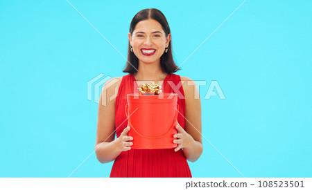 Birthday present, excited and woman in portrait in studio, celebration and giveaway isolated on blue background. Happiness, smile and winning with gift box, party with reward or bonus prize 108523501