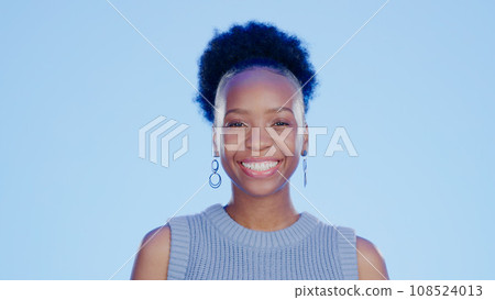 Smile, happy and portrait of black woman in a studio with positive, confident and good attitude. Excited, pride and young African female model with joy and happiness isolated by blue background. Smile, happy and portrait of black woman in a studio with positive, confident and good attitude. Excited, pride and young African female model with joy and happiness isolated by blue background. 108524013