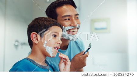 Dad, boy and learning to shave in bathroom with facial cream, skincare routine and support. Father, kid and teaching about cosmetics of cleaning face, beard and foam for love, care and family at home Dad, boy and learning to shave in bathroom with facial cream, skincare routine and support. Father, kid and teaching about cosmetics of cleaning face, beard and foam for love, care and family at home 108524270