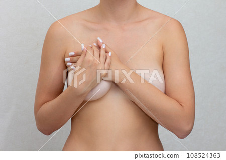 Cropped woman hands monitoring nodules, swellings or cysts on breast by fingers Cropped woman hands monitoring nodules, swellings or cysts on breast by fingers 108524363