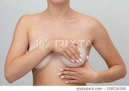 Cropped woman hands monitoring nodules, swellings or cysts on breast by fingers 108524388