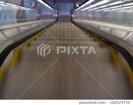 Top view, stairs and escalator in modern building for travel, moving and transport in airport. Metal, steel and closeup of electrical stairway in shopping mall, office or subway for urban commute Top view, stairs and escalator in modern building for travel, moving and transport in airport. Metal, steel and closeup of electrical stairway in shopping mall, office or subway for urban commute 108524738