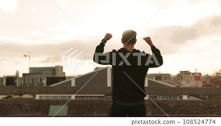 Man, runner or cheers in city for exercise time, fitness progress or training goal. Male person, athlete or victory or workout performance or cloudy morning in street, challenge or health celebration 108524774