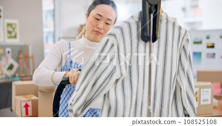 Asian woman, fashion designer and steam clothing in logistics, small business or quality service at boutique. Female person in dry cleaning, retail store or product preparation for delivery at shop Asian woman, fashion designer and steam clothing in logistics, small business or quality service at boutique. Female person in dry cleaning, retail store or product preparation for delivery at shop 108525108