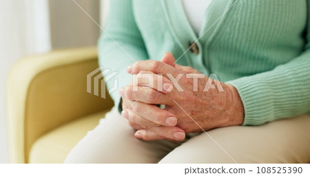 Hands, anxiety and senior woman on a sofa with stress, fear or grief, dementia or scared in her home. Stress, worry and nervous elderly female in a living room with Alzheimer, arthritis or depression 108525390