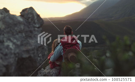 Hiking, mountain and sunrise, couple relax on outdoor adventure and peace in nature with romance from back. Trekking, rock climbing and love, man and woman with sunset horizon view on cliff together. 108525571