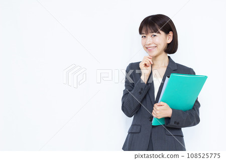 A 30's business woman in a suit thinking with a smile A 30's business woman in a suit thinking with a smile 108525775