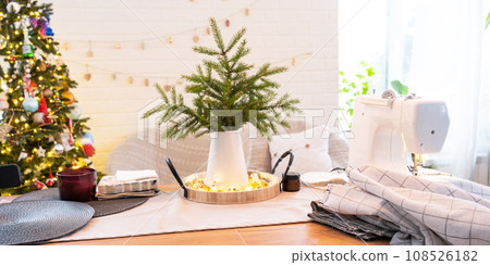 Sewing process on a sewing machine, a needle with a thread and a holder close-up stitch the white checkered fabric. Preparation for Christmas and new year, textiles for cozy in festive decor interior Sewing process on a sewing machine, a needle with a thread and a holder close-up stitch the white checkered fabric. Preparation for Christmas and new year, textiles for cozy in festive decor interior 108526182