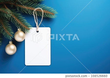 White blank price tag on blue background with Christmas tree branch. Copy space. White blank price tag on blue background with Christmas tree branch. Copy space. 108526660