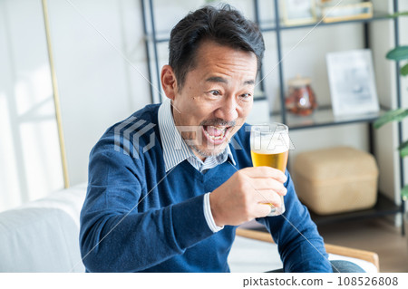 中年男子在客廳喝啤酒 中年男子在客廳喝啤酒 108526808