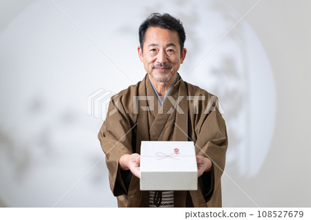 middle-aged man holding a gift 108527679