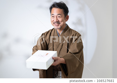 middle-aged man holding a gift middle-aged man holding a gift 108527681