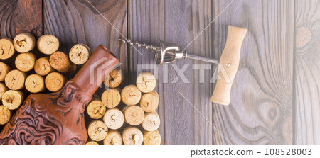 Bottle of wine with corks on wooden table background. on soft sunlight Bottle of wine with corks on wooden table background. on soft sunlight 108528003