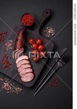 Delicious smoked sausage with salt and spices cut into slices 108528543