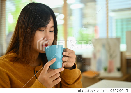 Pretty young Asian woman drinking hot tea in the morning at home 108529045