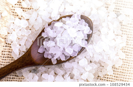 White bath salt in a wooden spoon on soft sunlight White bath salt in a wooden spoon on soft sunlight 108529434