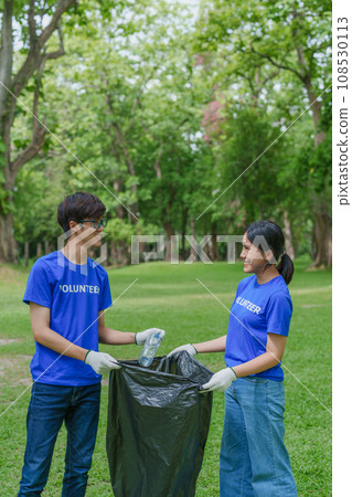 Multiethnic volunteers donate their time holding black garbage bags to collect plastic waste for recycling to reduce pollution in a public park Multiethnic volunteers donate their time holding black garbage bags to collect plastic waste for recycling to reduce pollution in a public park 108530113
