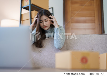 Starting small business entrepreneur of independent Asian woman showing her face worried about the sales of her business not reaching the target set. SME concepts. Starting small business entrepreneur of independent Asian woman showing her face worried about the sales of her business not reaching the target set. SME concepts. 108530155