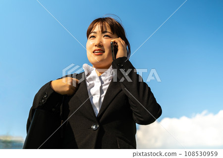一個穿著西裝的女人在路上接聽電話 一個穿著西裝的女人在路上接聽電話 108530959