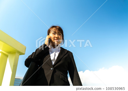 一個穿著西裝的女人在路上接聽電話 108530965