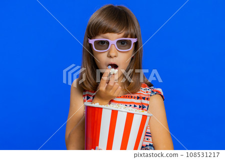 Excited child girl kid eating popcorn, watch tv serial, sport game, film, online social media movie Excited child girl kid eating popcorn, watch tv serial, sport game, film, online social media movie 108531217
