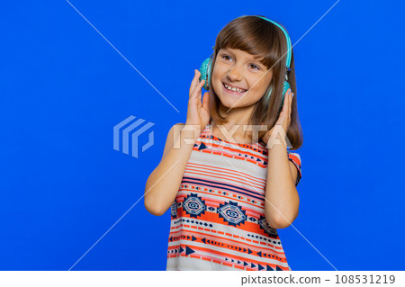 Caucasian child kid girl listening music on headphones, dancing disco fooling around having fun 108531219