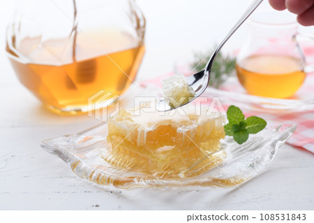 A fluffy floral scent with com honey (comb honey) served with honey dipper and honey pot. A fluffy floral scent with com honey (comb honey) served with honey dipper and honey pot. 108531843