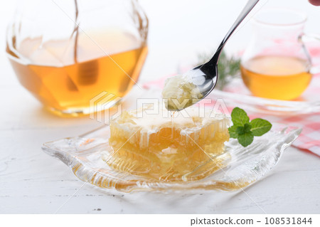 A fluffy floral scent with com honey (comb honey) served with honey dipper and honey pot. A fluffy floral scent with com honey (comb honey) served with honey dipper and honey pot. 108531844
