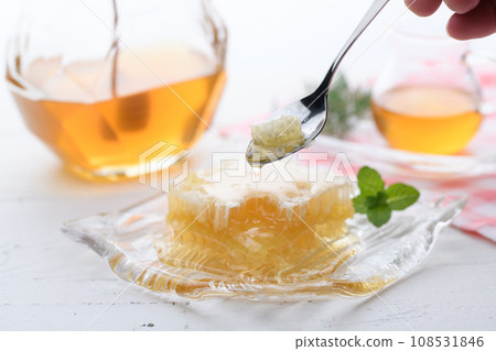 A fluffy floral scent with com honey (comb honey) served with honey dipper and honey pot. A fluffy floral scent with com honey (comb honey) served with honey dipper and honey pot. 108531846