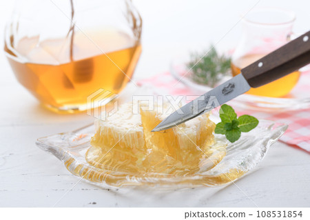 A fluffy floral scent with com honey (comb honey) served with honey dipper and honey pot. A fluffy floral scent with com honey (comb honey) served with honey dipper and honey pot. 108531854