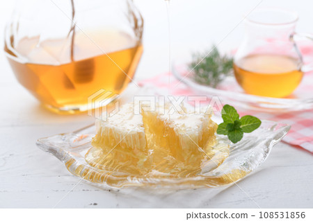 A fluffy floral scent with com honey (comb honey) served with honey dipper and honey pot. A fluffy floral scent with com honey (comb honey) served with honey dipper and honey pot. 108531856