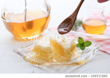 A fluffy floral scent with com honey (comb honey) served with honey dipper and honey pot. A fluffy floral scent with com honey (comb honey) served with honey dipper and honey pot. 108531860