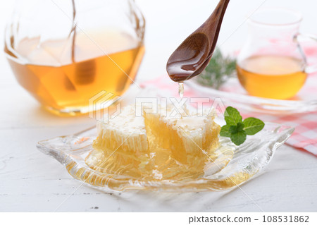 A fluffy floral scent with com honey (comb honey) served with honey dipper and honey pot. 108531862