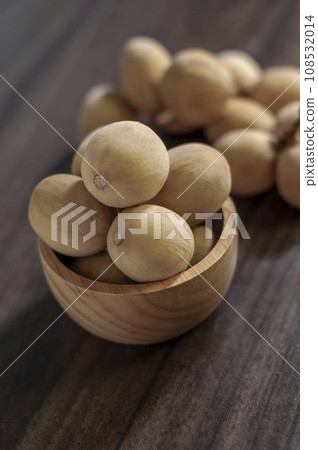 Langsat, Longkong, placed in a wooden cup set on a wooden board table dark blurred background Langsat, Longkong, placed in a wooden cup set on a wooden board table dark blurred background 108532014
