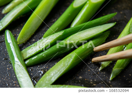 烹飪場景特寫，蒜苗（斜切）在煎鍋中煎炸。 108532094