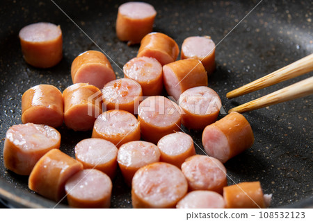 在煎鍋裡煎維也納香腸的烹飪場景。 在煎鍋裡煎維也納香腸的烹飪場景。 108532123