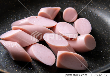A cooking scene where fish sausage (diagonally cut) is stir-fried in a frying pan. A cooking scene where fish sausage (diagonally cut) is stir-fried in a frying pan. 108532137