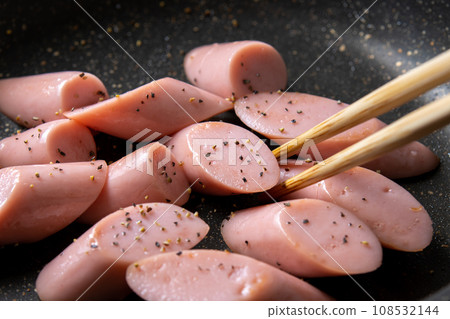 A cooking scene where fish sausage (diagonally cut) is stir-fried in a frying pan. (Fried black pepper) 108532144