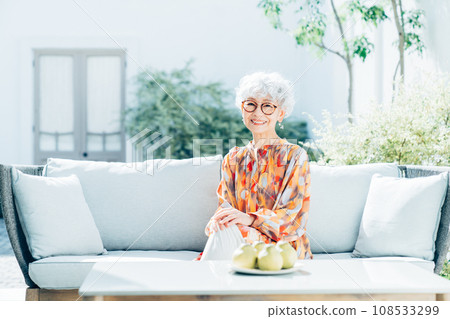 Senior woman relaxing in outdoor living room Senior woman relaxing in outdoor living room 108533299