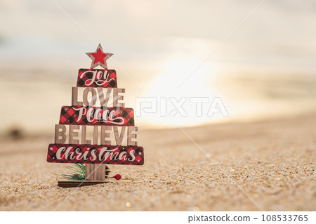 Wooden christmas tree toy on the beach 108533765