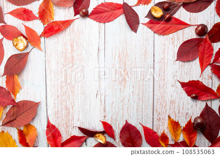 Autumn leaves and chestnuts on wooden background. Flat lay, top view, copy space. Autumn leaves and chestnuts on wooden background. Flat lay, top view, copy space. 108535063