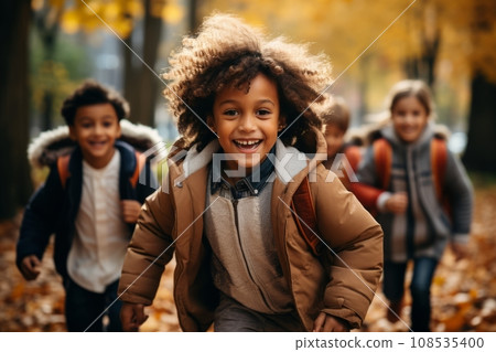 Cheerful multiethnic children group running along autumn park alley. Happy smiling boys and girls of different skin colors play and have fun together. Diversity and free communication concept. Cheerful multiethnic children group running along autumn park alley. Happy smiling boys and girls of different skin colors play and have fun together. Diversity and free communication concept. 108535400