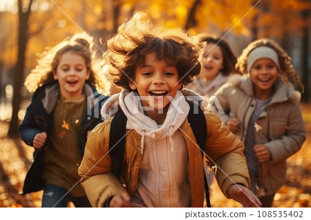 Cheerful multiethnic children group running along autumn park alley. Happy smiling boys and girls of different skin colors play and have fun together. Diversity and free communication concept. 108535402