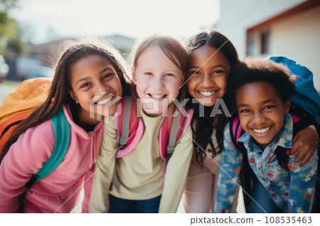 Happy smiling multiethnic kids posing for group portrait in a school yard. Cheerful schoolchildren hugging and looking at camera. Kids of different skin color go to school together. Diversity concept. 108535463